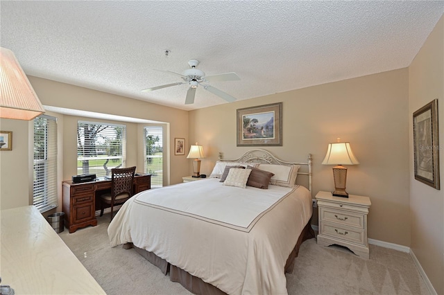 carpeted bedroom featuring ceiling fan and a textured ceiling