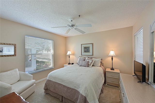 bedroom with ceiling fan, light carpet, and a textured ceiling