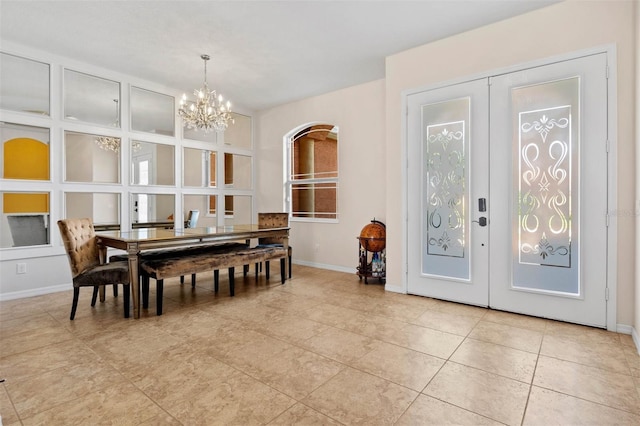 tiled dining space featuring a notable chandelier and french doors