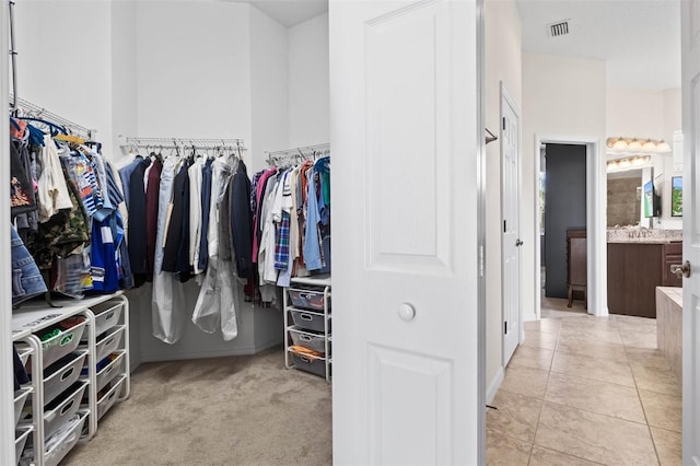 walk in closet with light tile patterned floors