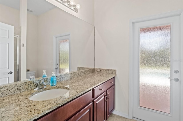 bathroom featuring walk in shower, vanity, and toilet