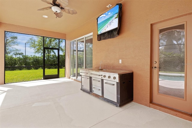 unfurnished sunroom with sink and ceiling fan