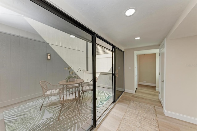 hallway with floor to ceiling windows and light hardwood / wood-style floors