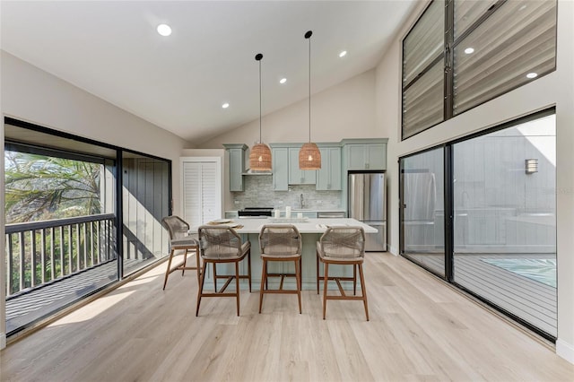 dining area with high vaulted ceiling and light wood-type flooring