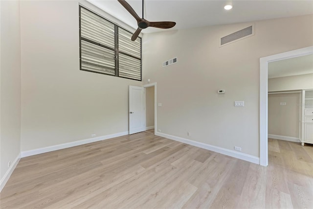 unfurnished room featuring light hardwood / wood-style flooring, high vaulted ceiling, and ceiling fan