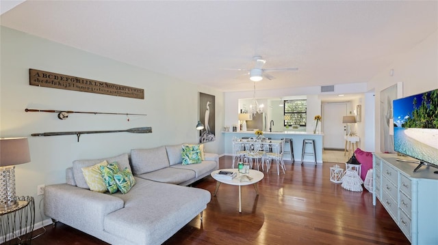 living room with ceiling fan with notable chandelier, wood-type flooring, and sink