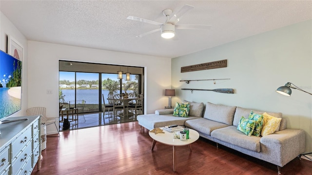 living room featuring hardwood / wood-style floors, ceiling fan, a textured ceiling, and a water view