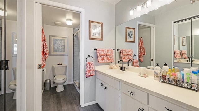 bathroom featuring hardwood / wood-style flooring, vanity, toilet, and an enclosed shower