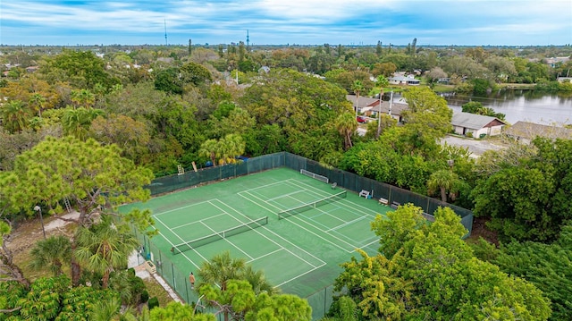 view of tennis court with a water view