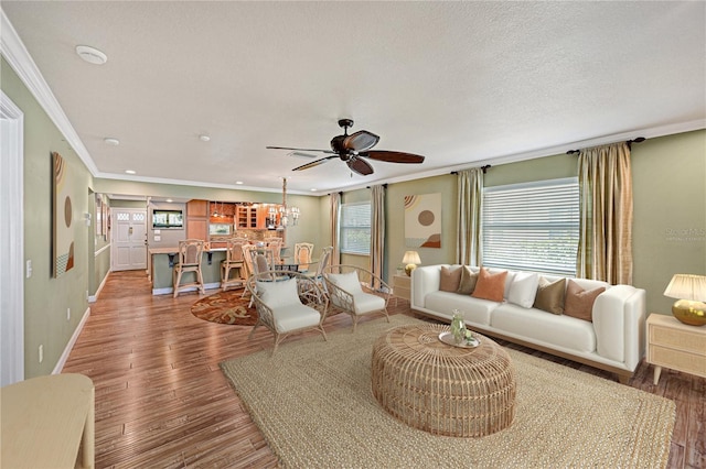 living room featuring ceiling fan, ornamental molding, dark hardwood / wood-style floors, and a wealth of natural light