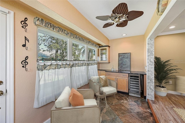 living area with recessed lighting, beverage cooler, a ceiling fan, baseboards, and stone finish floor