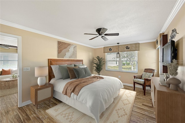 bedroom featuring ornamental molding, wood finished floors, and baseboards