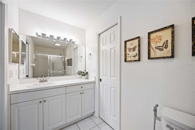 bathroom with an enclosed shower, vanity, tile patterned floors, and toilet