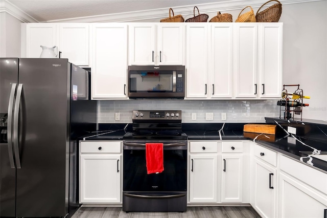 kitchen featuring stainless steel range with electric stovetop, refrigerator with ice dispenser, decorative backsplash, and white cabinets