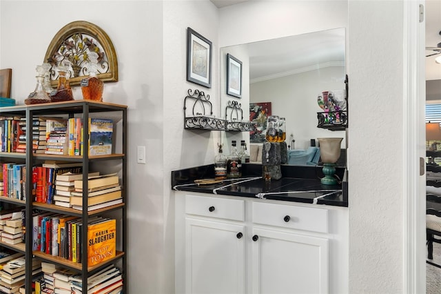 bar featuring white cabinetry and crown molding