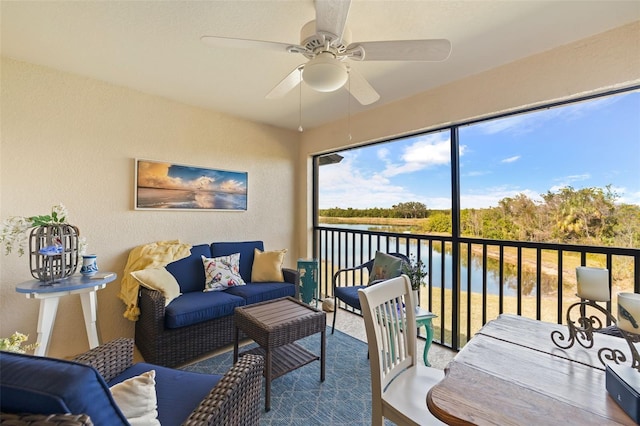 sunroom / solarium featuring ceiling fan and a water view