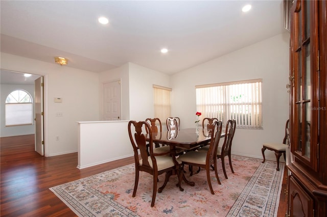 dining room featuring vaulted ceiling and dark hardwood / wood-style floors