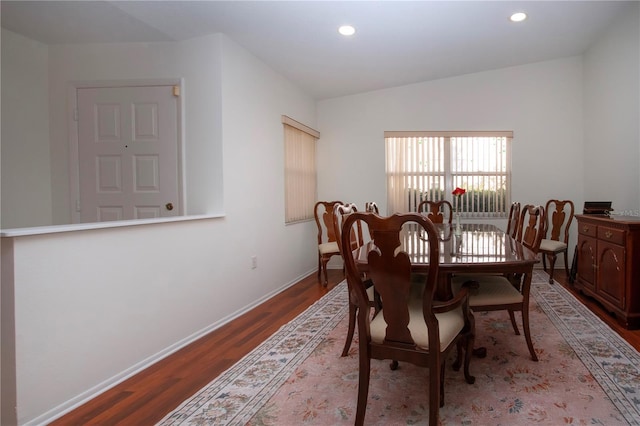 dining area featuring dark hardwood / wood-style flooring and vaulted ceiling