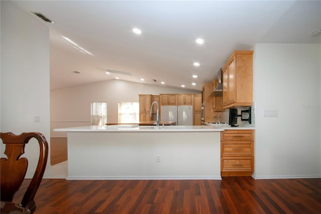 kitchen featuring sink, vaulted ceiling, light brown cabinets, white refrigerator, and dark hardwood / wood-style floors