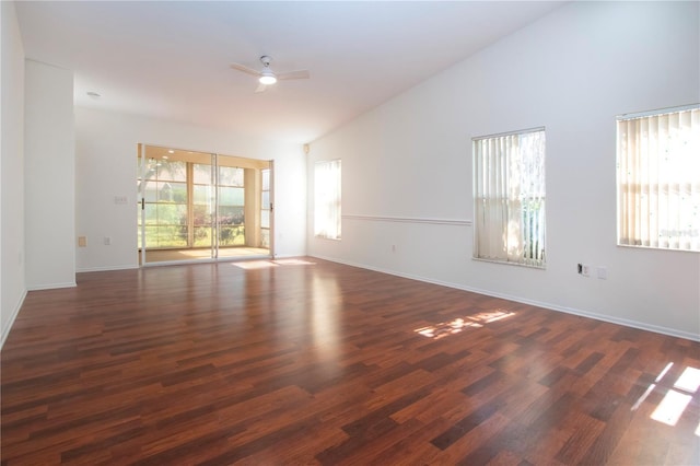 empty room with high vaulted ceiling, dark wood-type flooring, and ceiling fan