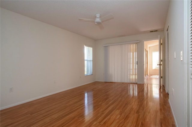 empty room with wood-type flooring, a textured ceiling, and ceiling fan