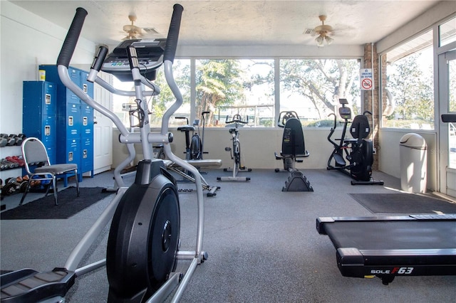 gym with ceiling fan, a healthy amount of sunlight, and a textured ceiling