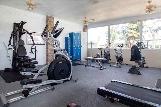 gym with ceiling fan and a textured ceiling