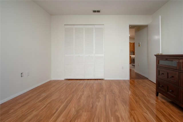 unfurnished bedroom featuring light hardwood / wood-style floors and a closet