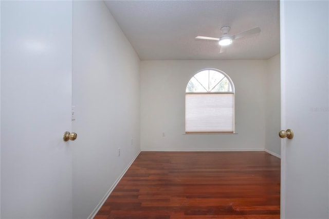 spare room featuring dark wood-type flooring and ceiling fan