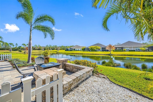 view of yard featuring a patio, a water view, and an outdoor fire pit