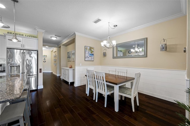 dining room with an inviting chandelier, ornamental molding, dark hardwood / wood-style floors, and a textured ceiling