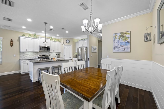 dining space with a notable chandelier, crown molding, and dark hardwood / wood-style floors