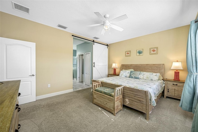 bedroom with light carpet, a textured ceiling, a barn door, and ceiling fan