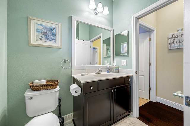 bathroom featuring hardwood / wood-style flooring, vanity, and toilet