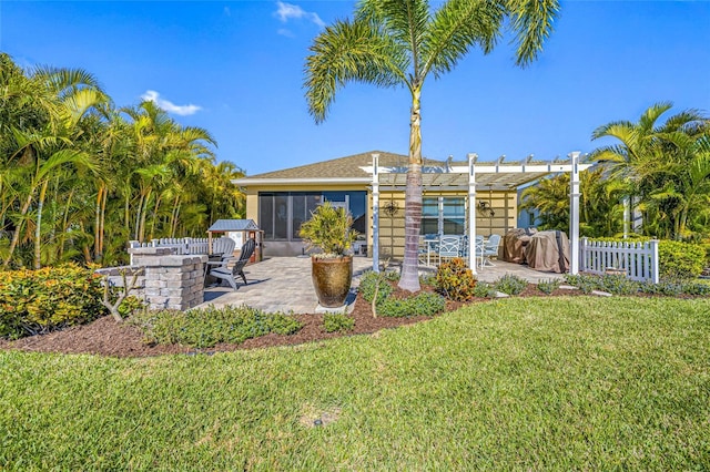 back of house featuring a pergola, a yard, a sunroom, and a patio area