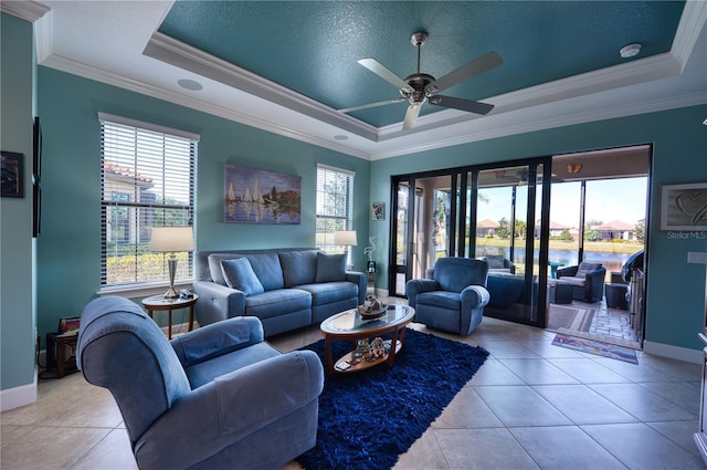 tiled living room featuring ornamental molding, a textured ceiling, and a tray ceiling