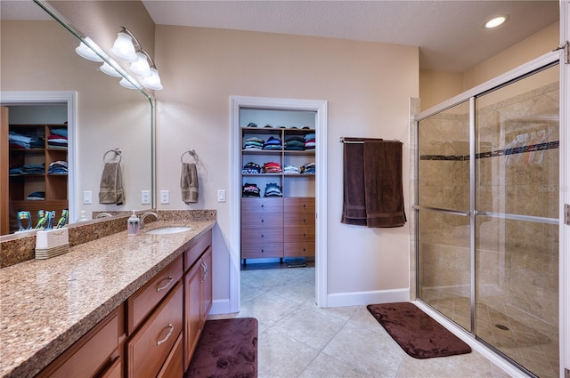 bathroom with vanity, tile patterned flooring, and a shower with door