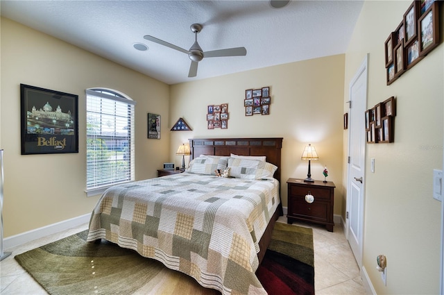 tiled bedroom featuring a textured ceiling and ceiling fan