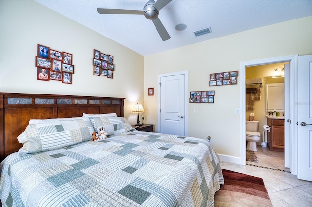 bedroom with light tile patterned flooring, ensuite bathroom, and ceiling fan