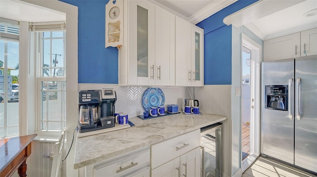 kitchen with white cabinetry, stainless steel fridge, light stone countertops, and wine cooler