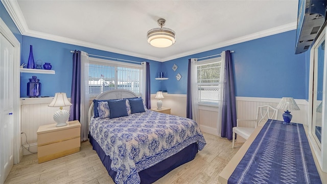 bedroom with multiple windows, ornamental molding, and light wood-type flooring