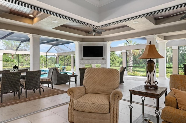 sunroom with ceiling fan and a tray ceiling