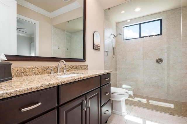 bathroom featuring crown molding, tile patterned flooring, vanity, a tile shower, and toilet