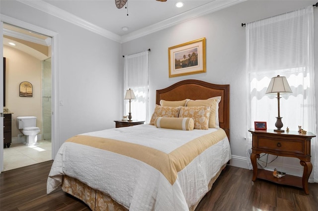 bedroom featuring crown molding, dark wood-type flooring, ceiling fan, and ensuite bath