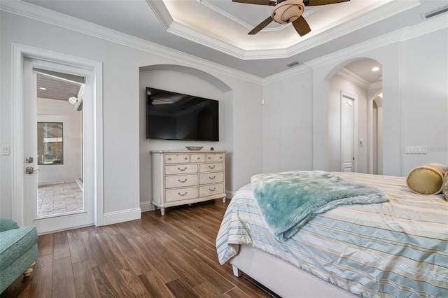 bedroom with dark hardwood / wood-style flooring, a tray ceiling, and ornamental molding