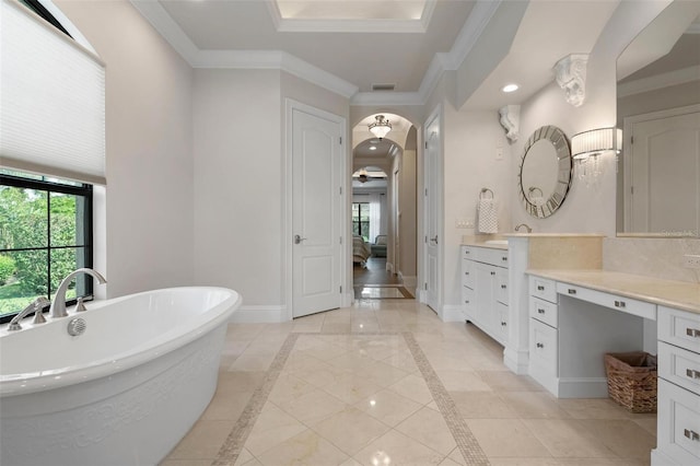 bathroom with crown molding, tasteful backsplash, vanity, a bathing tub, and a raised ceiling