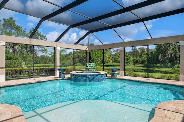 view of pool with an in ground hot tub, pool water feature, glass enclosure, and a patio area