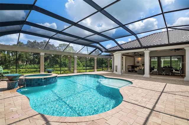 view of pool with an in ground hot tub, ceiling fan, glass enclosure, an outdoor living space, and a patio area