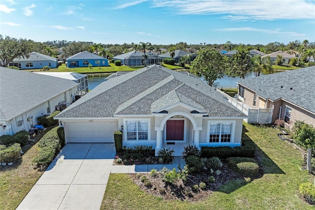 ranch-style home featuring a garage, a water view, and a front yard