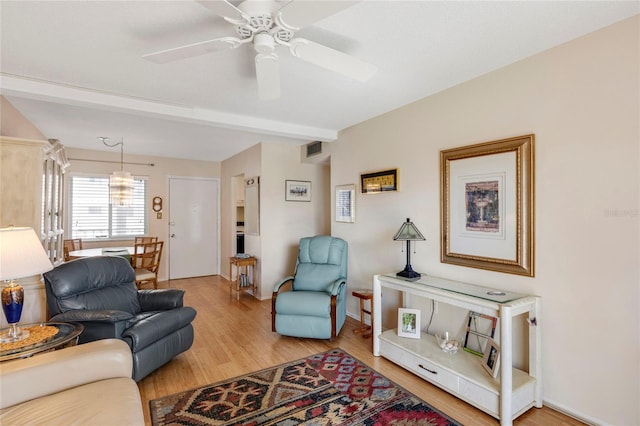 living room with hardwood / wood-style floors, beamed ceiling, and ceiling fan